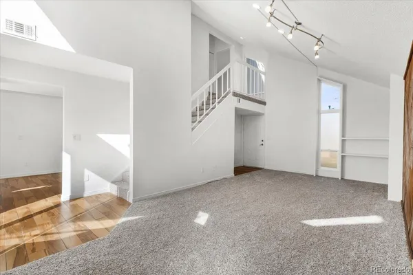 a view of an empty room with entryway and stairs
