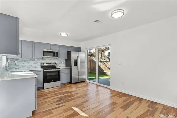 a kitchen with stainless steel appliances granite countertop a refrigerator stove top oven and sink