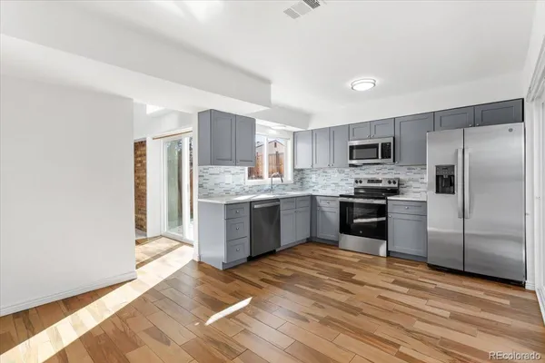 a kitchen with a refrigerator a sink a stove a microwave and cabinets