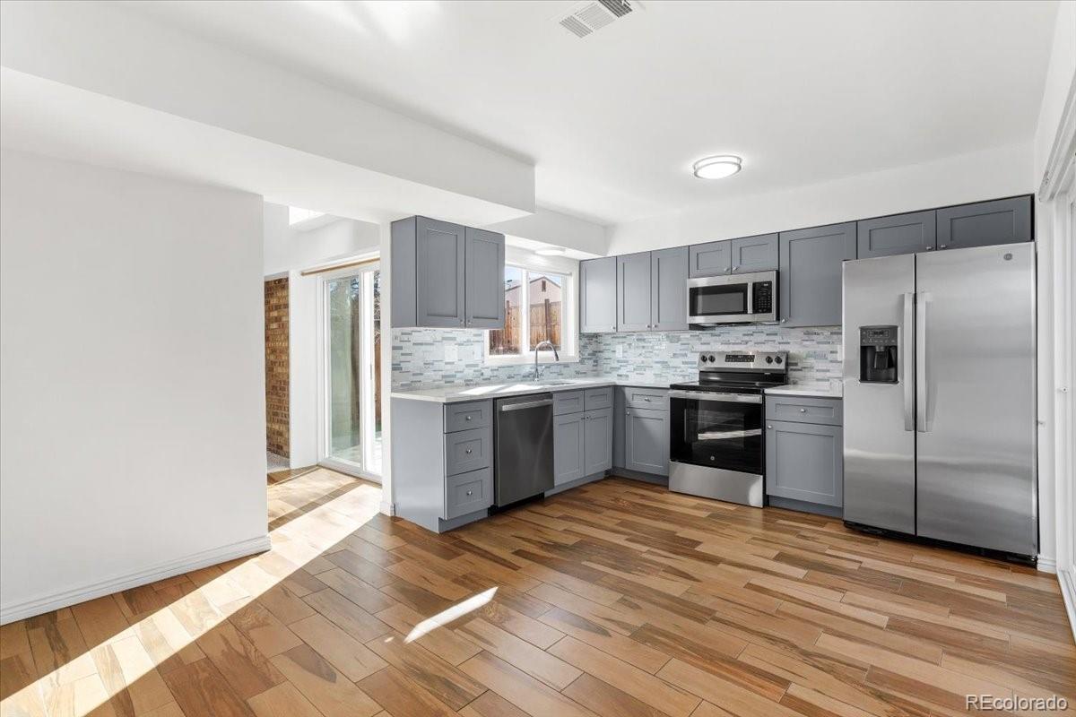 16222 East Rice Place, Unit B Aurora, CO 80015 - Photo 10 of 31 a kitchen with a refrigerator a sink a stove a microwave and cabinets