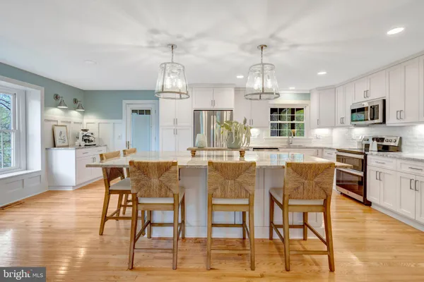 a dining area with stainless steel appliances kitchen island granite countertop a dining table chairs and view kitchen
