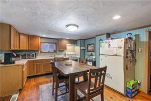 283 Duck Hollow Road Uniontown, PA 15401 - Photo 15 of 38 a kitchen with a refrigerator a stove a sink dishwasher and a dining table with garden view