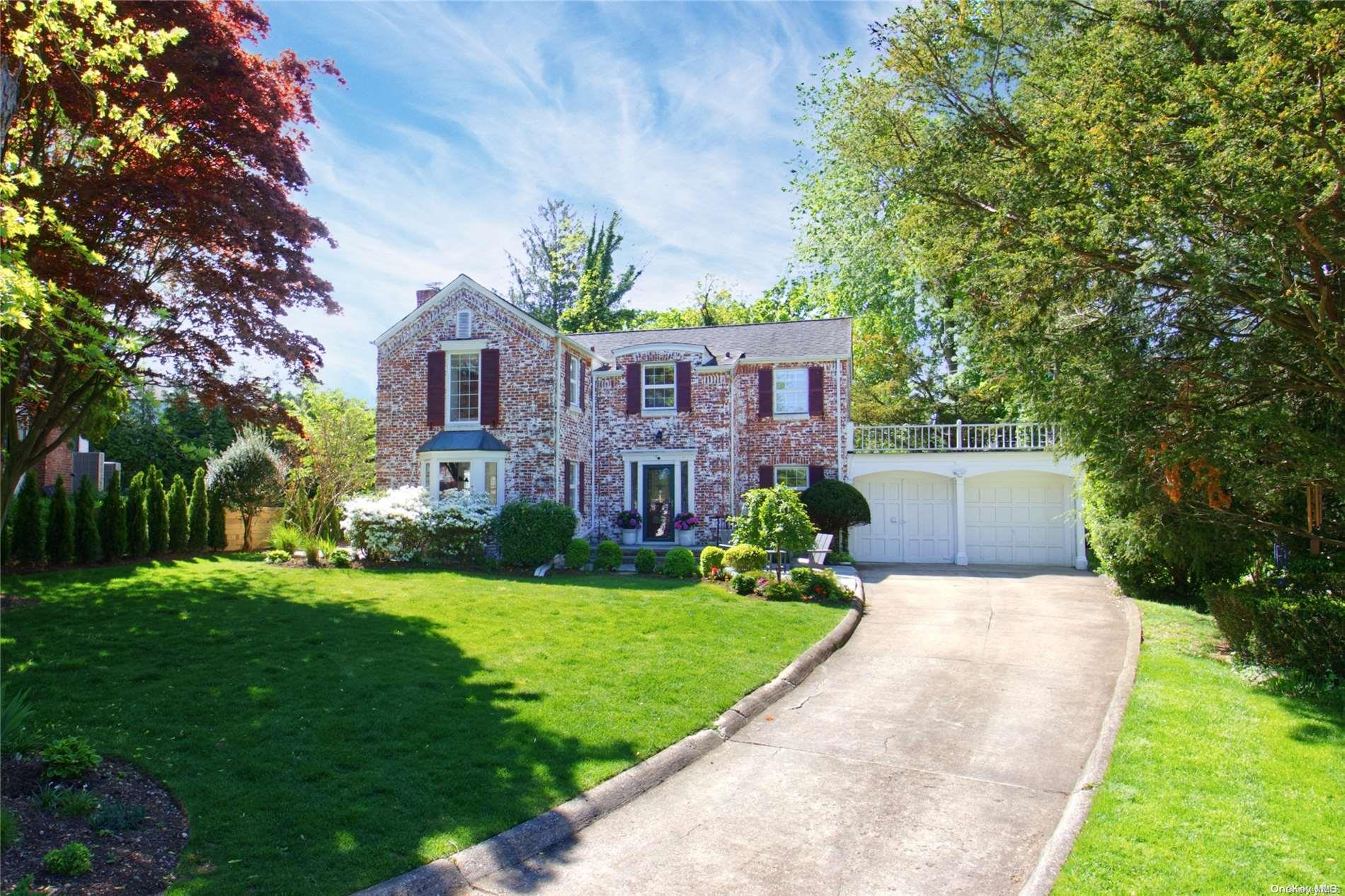 a front view of a house with a garden and yard