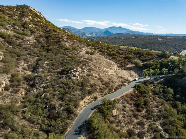 an aerial view of residential houses with outdoor space and trees