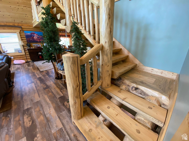 79 Auburn Forest Road Auburn, WY 83111 - Photo 37 of 76 Stairway featuring log walls, hardwood / wood-style floors, and a high ceiling