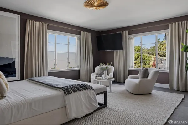 a bedroom with furniture and a large window
