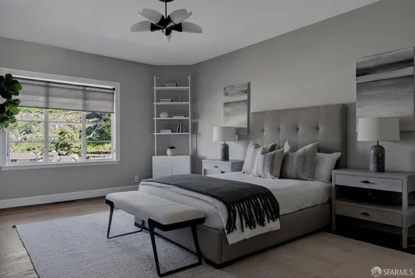 a bedroom with a bed a chandelier and a window