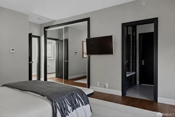 a bedroom with a bed and a flat screen tv