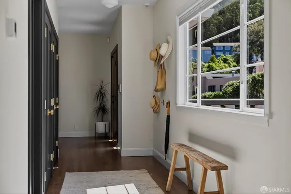 a view of hallway with wooden floor and windows