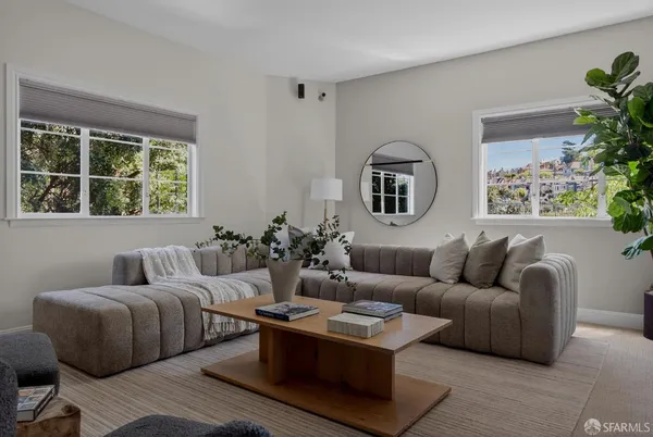 a living room with furniture and a potted plant