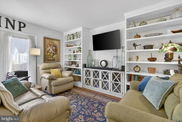 a living room with furniture a rug and a flat screen tv