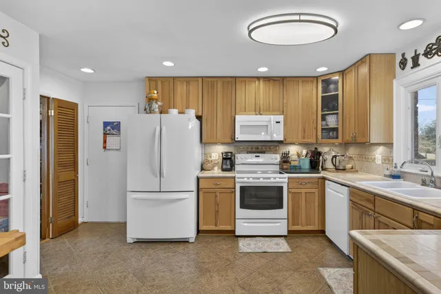 a large kitchen with kitchen island a large counter top stainless steel appliances and cabinets
