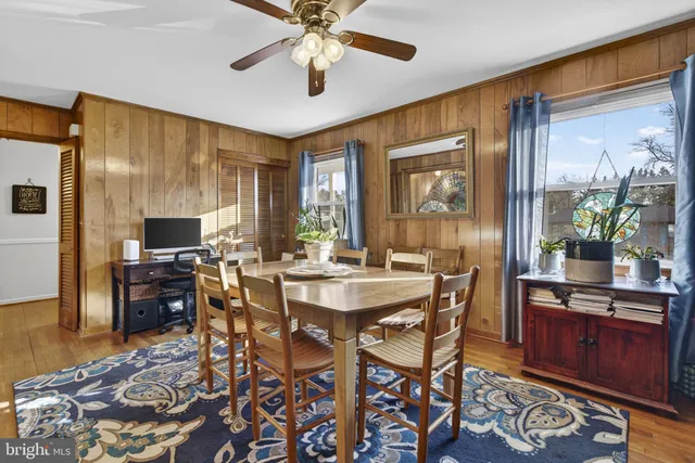 a dining room with furniture a floor to ceiling window and a kitchen