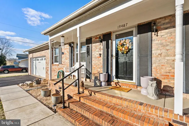 a kitchen with stainless steel appliances kitchen island granite countertop a refrigerator a stove and a wooden floors