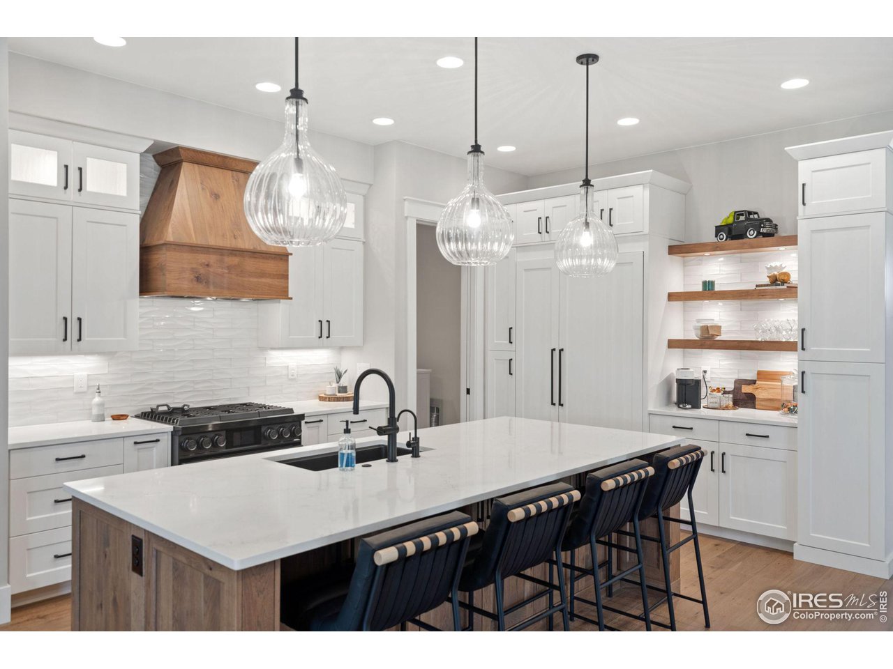 6475 Sanctuary Drive Windsor, CO 80550 - Photo 8 of 37 a kitchen with a table a sink cabinets and stainless steel appliances