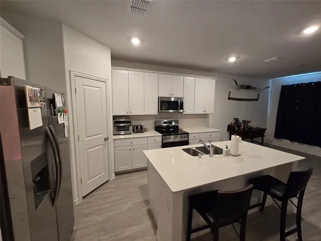 a kitchen with a refrigerator a stove a sink dishwasher and a refrigerator with wooden floor