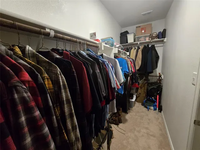 a view of walk in closet with clothes and shoes