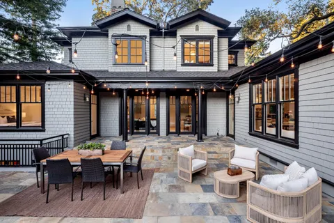 a kitchen with stainless steel appliances granite countertop a table chairs stove and cabinets