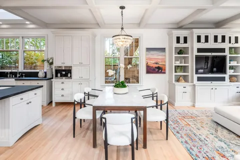 a dining room with furniture a chandelier and wooden floor