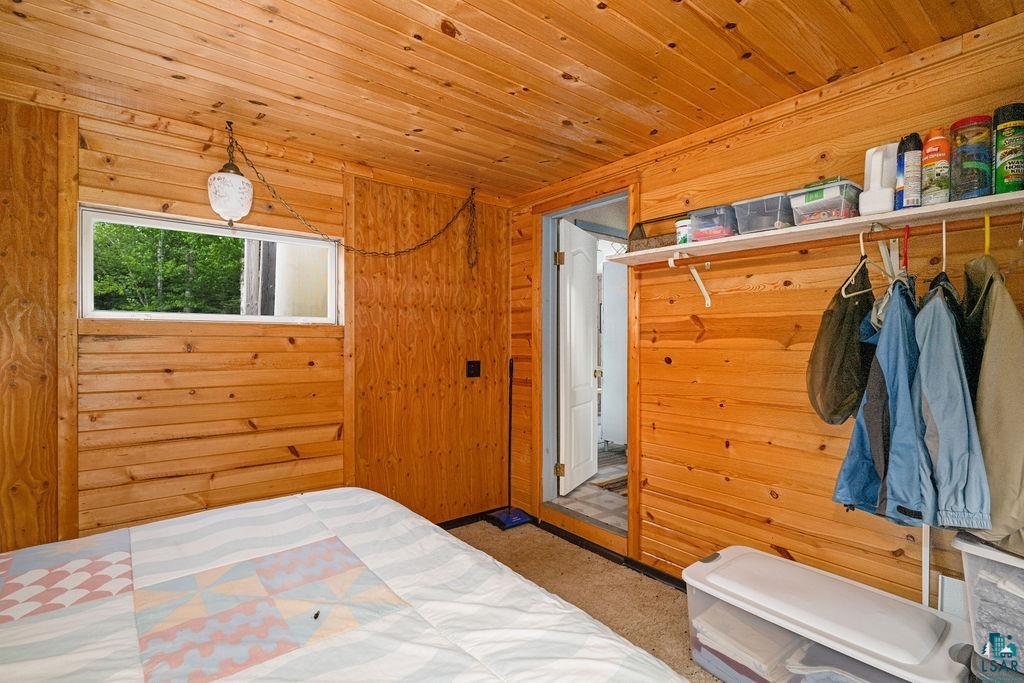 1268 Tom Lake Road Hovland, MN 55606 - Photo 52 of 56 Wood-paneled room featuring a horizontal window, ceiling-mounted light fixture, and carpet flooring