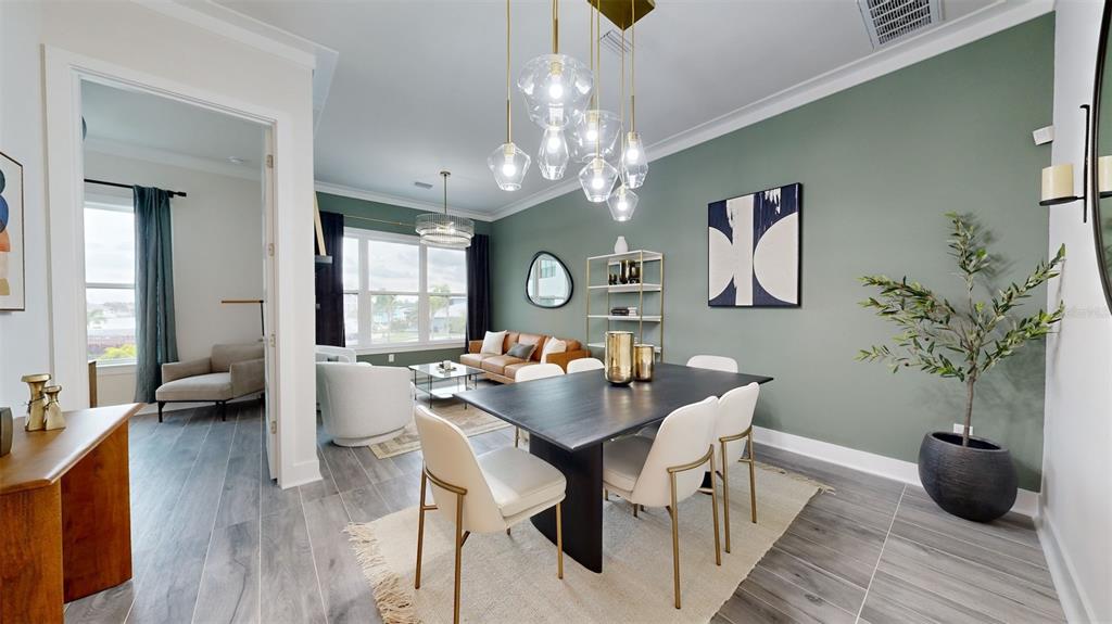 772 Gran Kaymen Way Apollo Beach, FL 33572 - Photo 17 of 43 a dining room with wooden floor a chandelier a wooden table and chairs