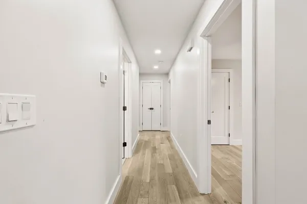 a view of a hallway with wooden floor