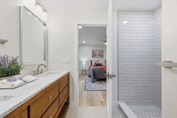 a en suite bathroom with a granite countertop sink and a mirror