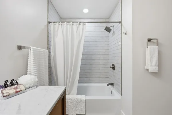 a bathroom with a tub shower and sink