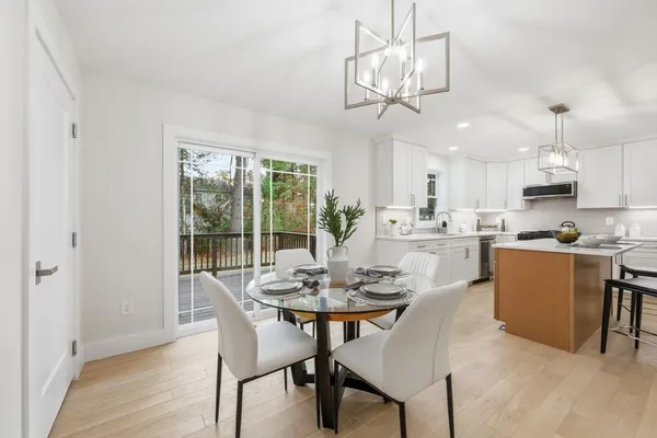 a dining room with wooden floor and a chandelier
