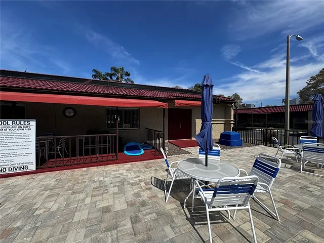 a view of a patio with a dining table and chairs with wooden floor