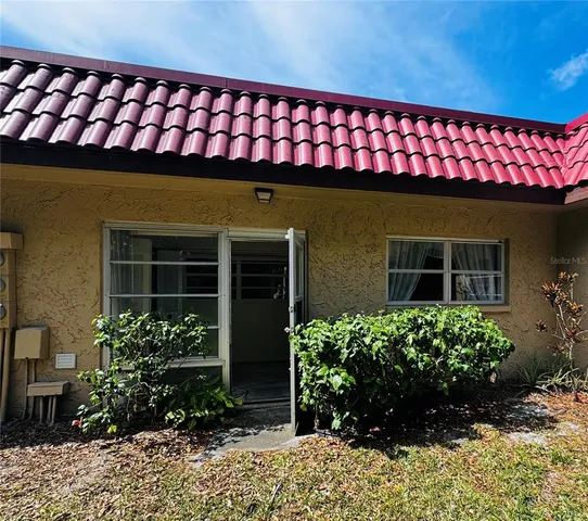 a front view of a house with a lots of flower plants
