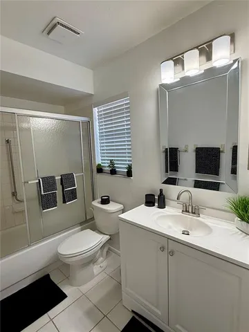 a bathroom with a double vanity sink toilet mirror and shower