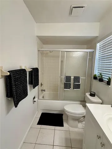 a bathroom with a sink a toilet a mirror and shower