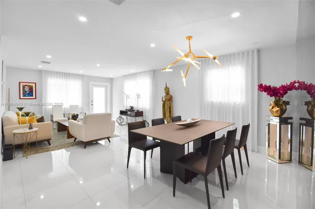 a living room with furniture a chandelier and a table