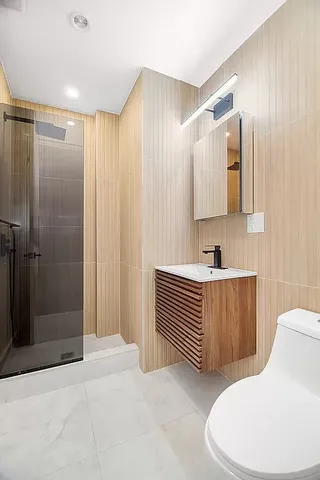a bathroom with a sink a toilet and shower