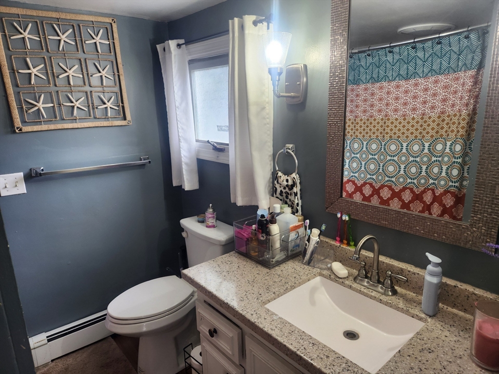 53 Temple Street Spencer, MA 01562 - Photo 13 of 20 a bathroom with a sink mirror vanity and toilet