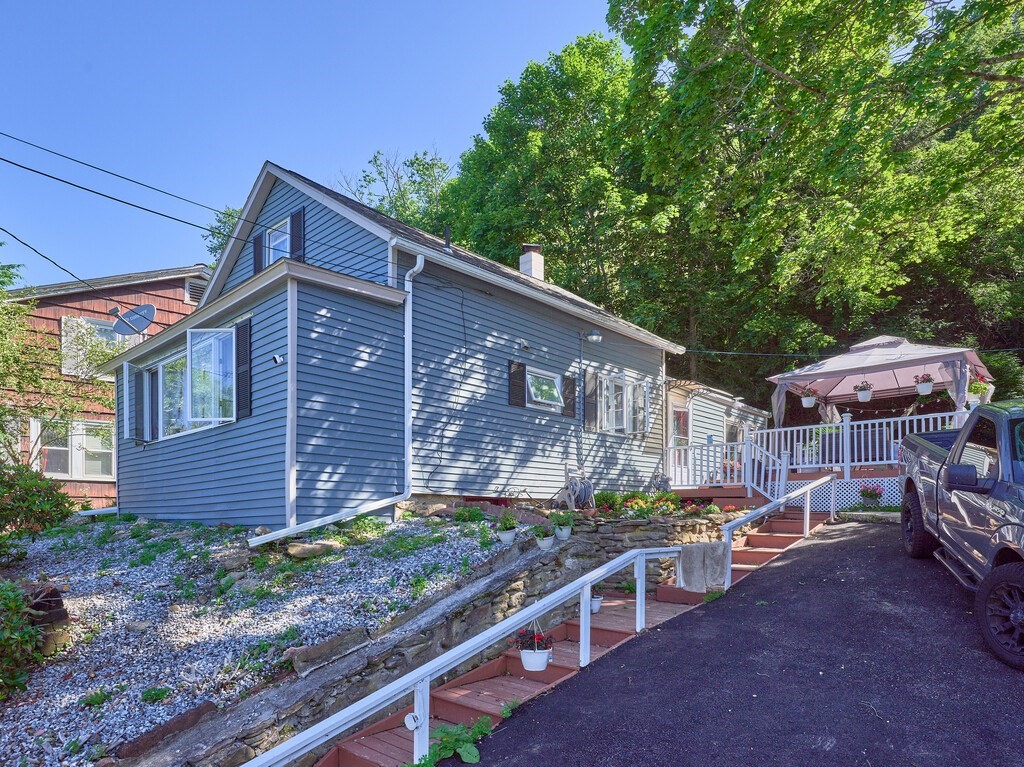 53 Temple Street Spencer, MA 01562 - Photo 3 of 20 a view of a house with a yard and wooden fence