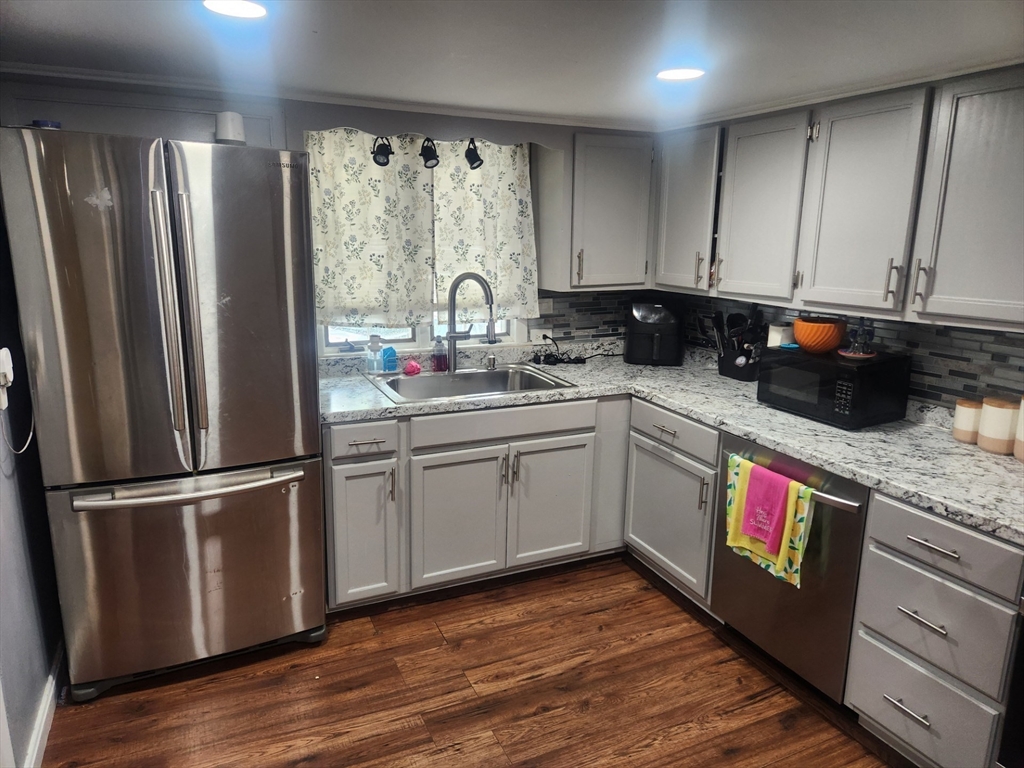 53 Temple Street Spencer, MA 01562 - Photo 10 of 20 a kitchen with stainless steel appliances granite countertop a refrigerator a sink dishwasher a stove and white cabinets with wooden floor