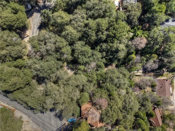 an aerial view of residential house with outdoor space and trees all around