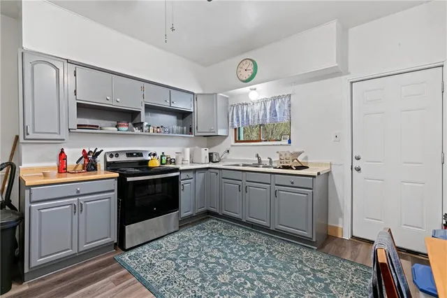 a kitchen with stainless steel appliances granite countertop a refrigerator a stove and a sink