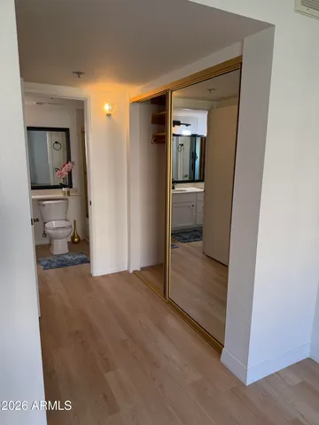 a view of a hallway with wooden floor and closet