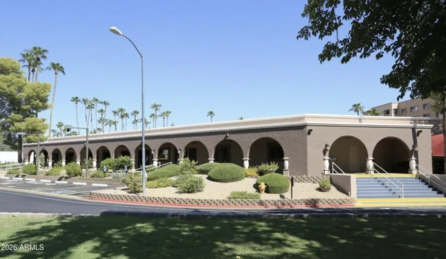 a living room with furniture lots of books and a large window