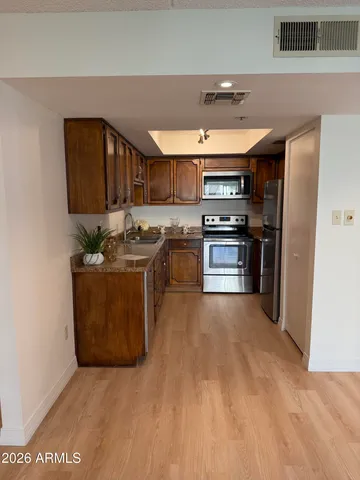 a kitchen with stainless steel appliances granite countertop a stove a sink and a refrigerator