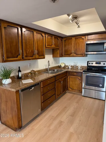 a kitchen with stainless steel appliances granite countertop a sink a stove and a microwave