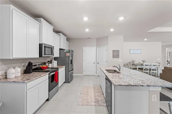 a kitchen that has a lot of cabinets in it and wooden floors