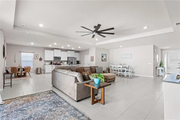 a living room with furniture and view of kitchen