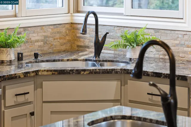 a close view of a stove and white cabinets with wooden floor