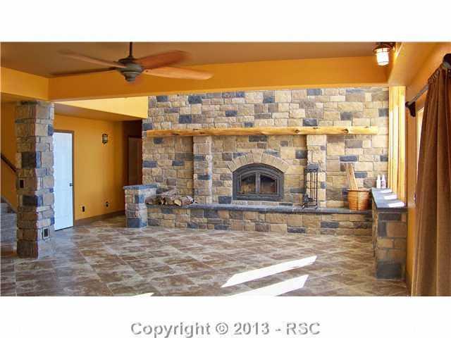 16835 Roller Coaster Road Colorado Springs, CO 80921 - Photo 22 of 25 This wood burning fireplace is built to heat the whole house! Great room walks out to covered concrete patio-wired for a hot tub!!