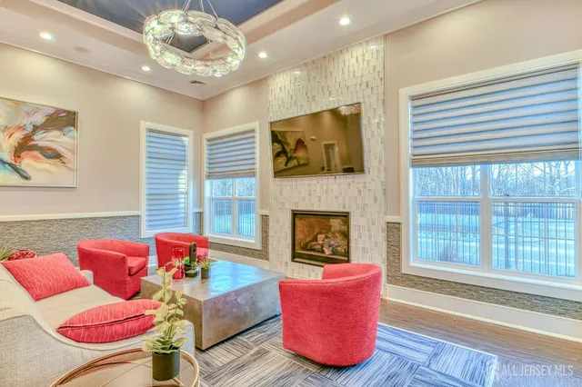 a living room with furniture a fireplace and a large window