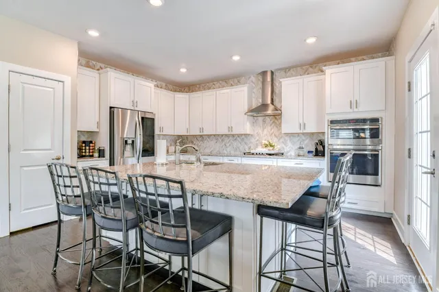 a kitchen with granite countertop a refrigerator sink stove and cabinets